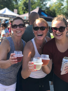 A group of ladies at a summer festival holding HaloVino wine tumblers.
